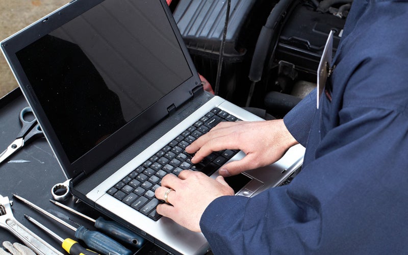 service technician typing on laptop
