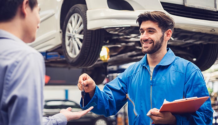car mechanic handing key to customer